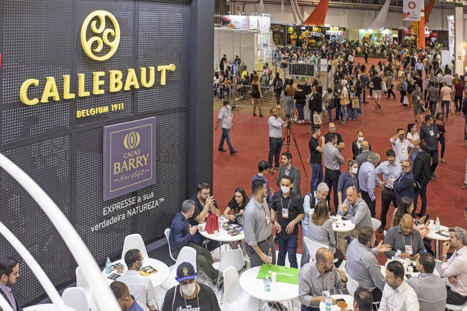 estande cheio de pessoas visto de cima na lateral as logos da Callebaut e Cacao Barry